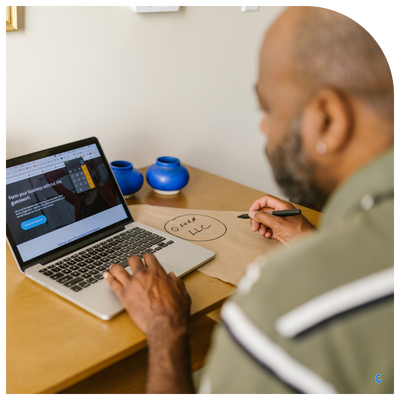 Black business owner reviewing professional website mockup and LLC branding on laptop.