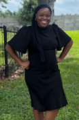 Ellie Canty, founder of Canty Media Group, standing outside in a black dress and heels, smiling confidently.